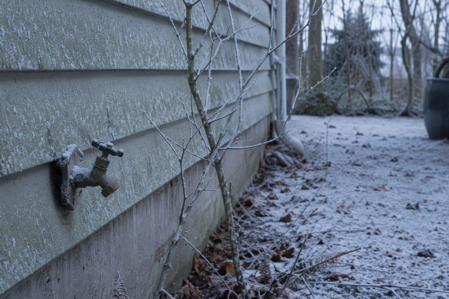 The frosted exterior wall and outdoor faucet of a Salem home on a cold winter morning